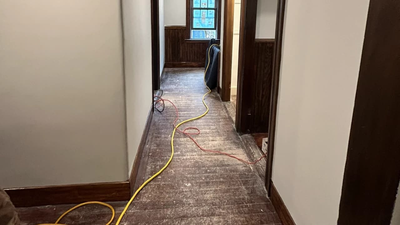 Old hardwood hallway floor before refinishing, pre-sanding stage