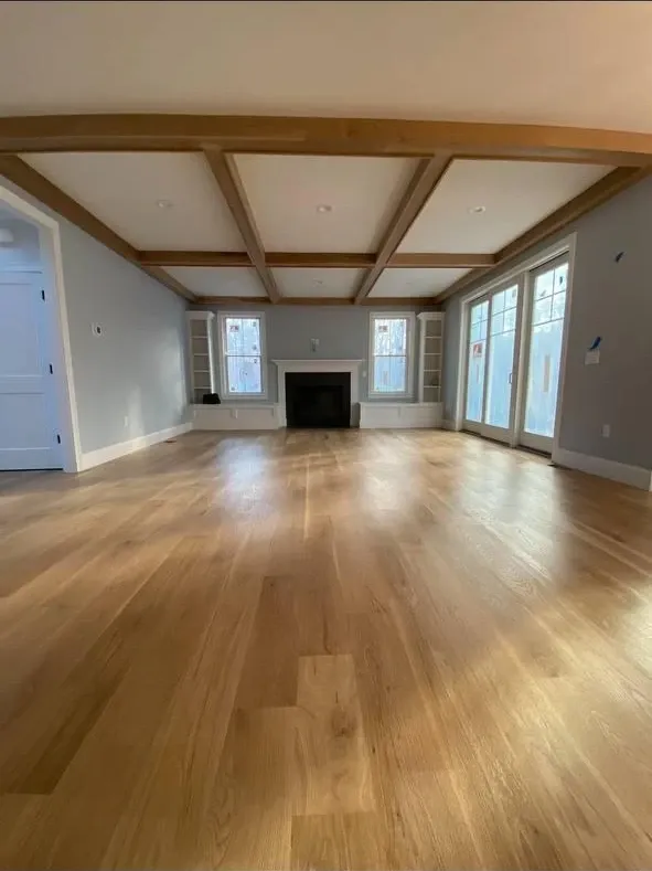 Wide-plank white oak hardwood floor installed by Kovich & Savard in a Massachusetts living room with coffered ceiling